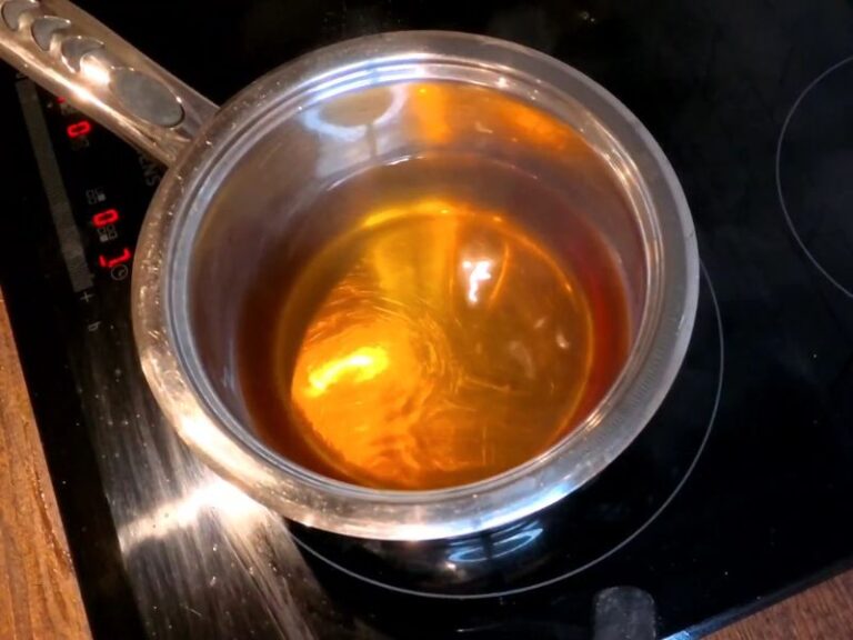 osoba kuva rakiju u šerpici na indukcionoj ploči