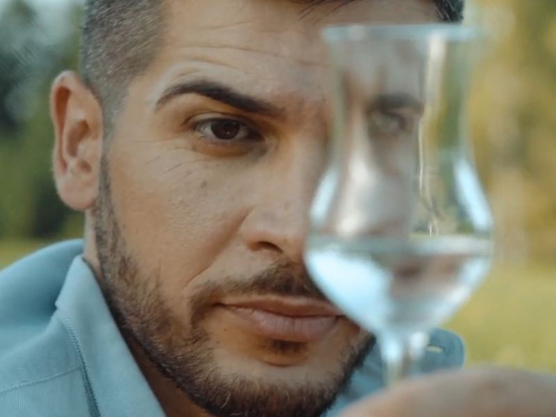 momak gleda u čašicu sa rakijom